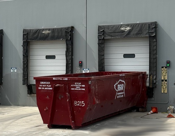 A Bear Services bin positioned at a commercial loading dock